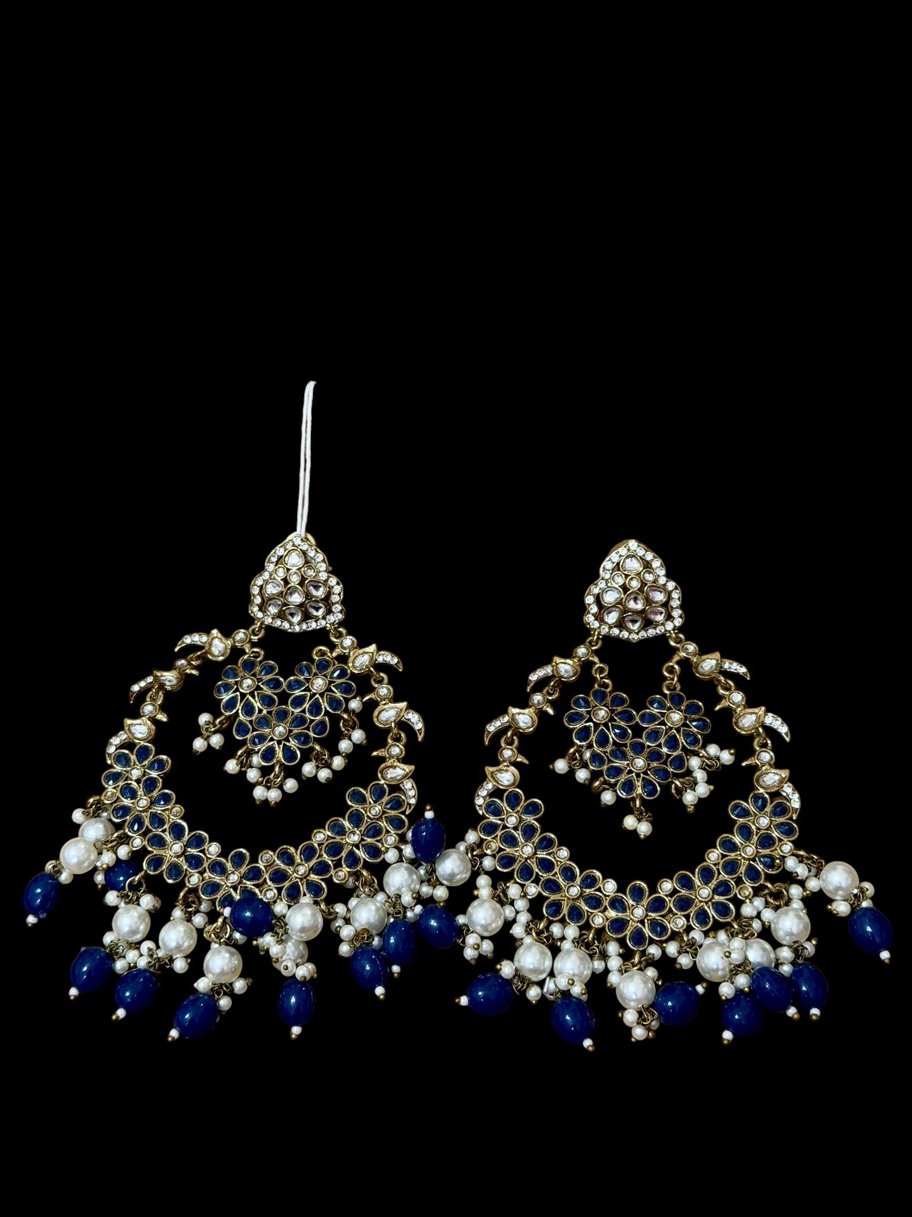 Ornate earrings with blue and white beads on a black background
